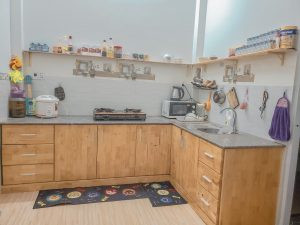 alt text: Bếp nhà cấp 4 nông thôn, sử dụng kệ treo tường